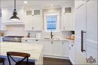 White kitchen, traditional, gorgeous countertops, contrast handles, long handles, black finishes, covered fridge, built-in fridge, built-in dishwasher
